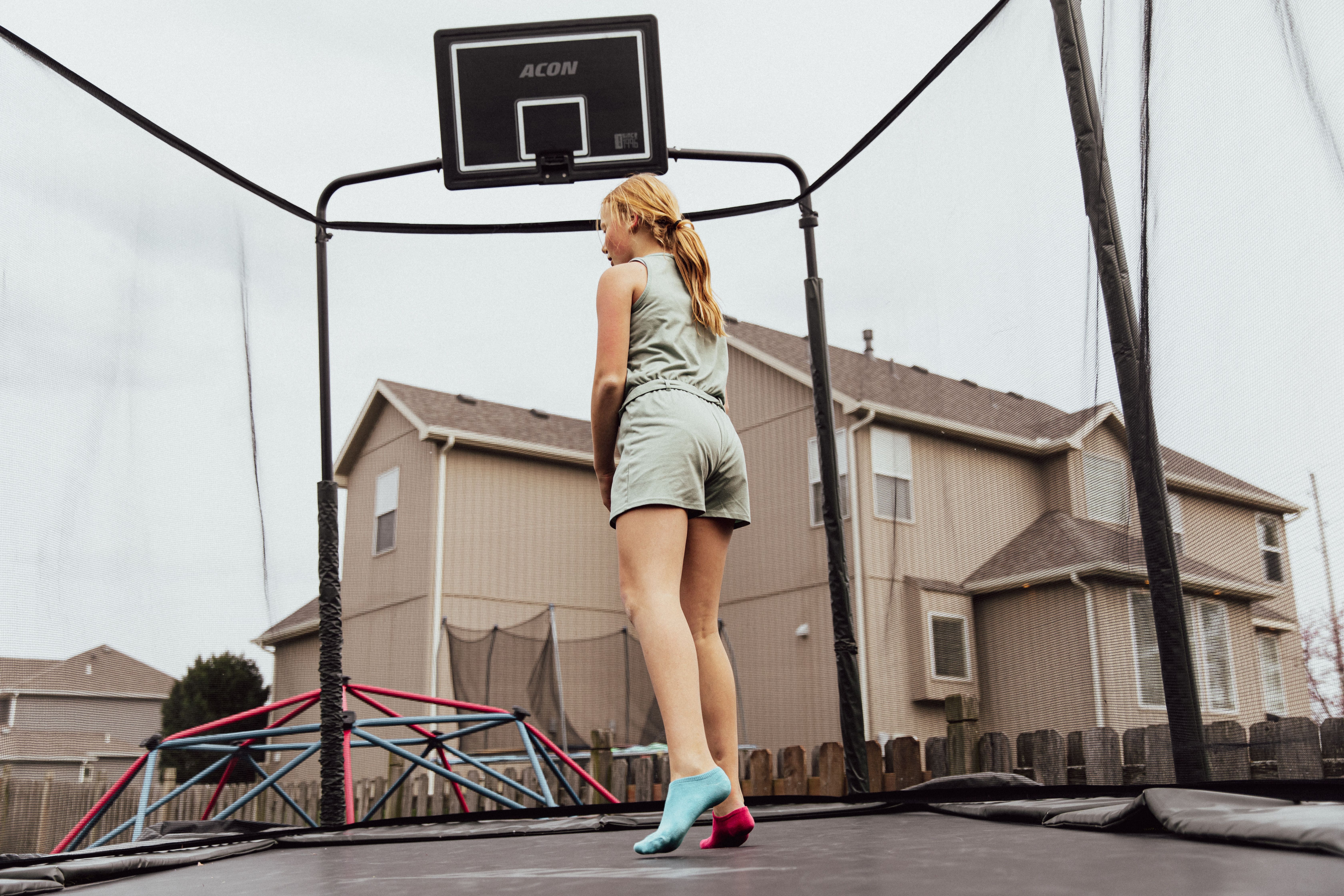 trampoline rental for parties egypt — Woman enjoying leisure time on a trampoline in an outdoor backyard setting.
