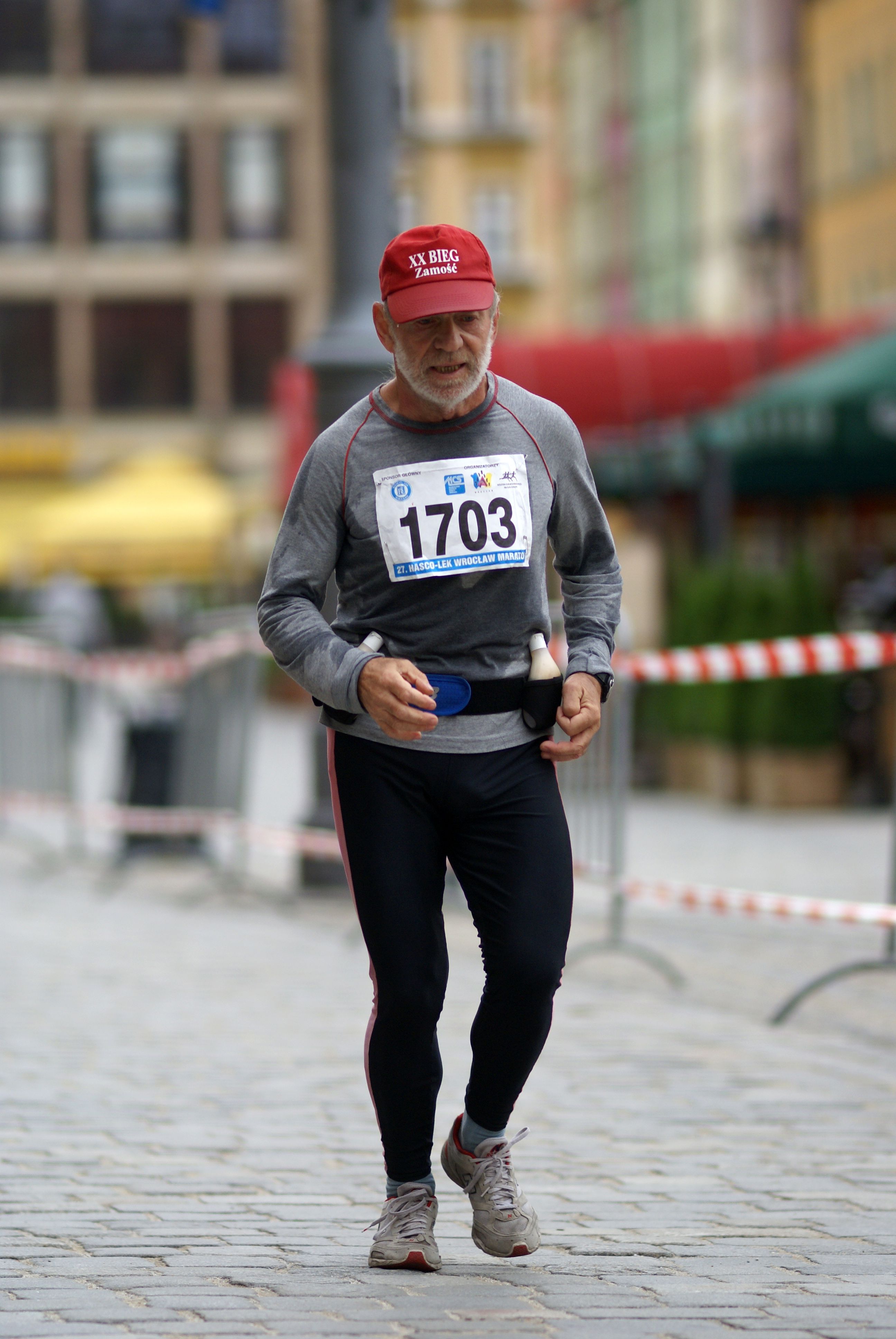 Senior athlete in action at a city marathon, showcasing determination and fitness.
