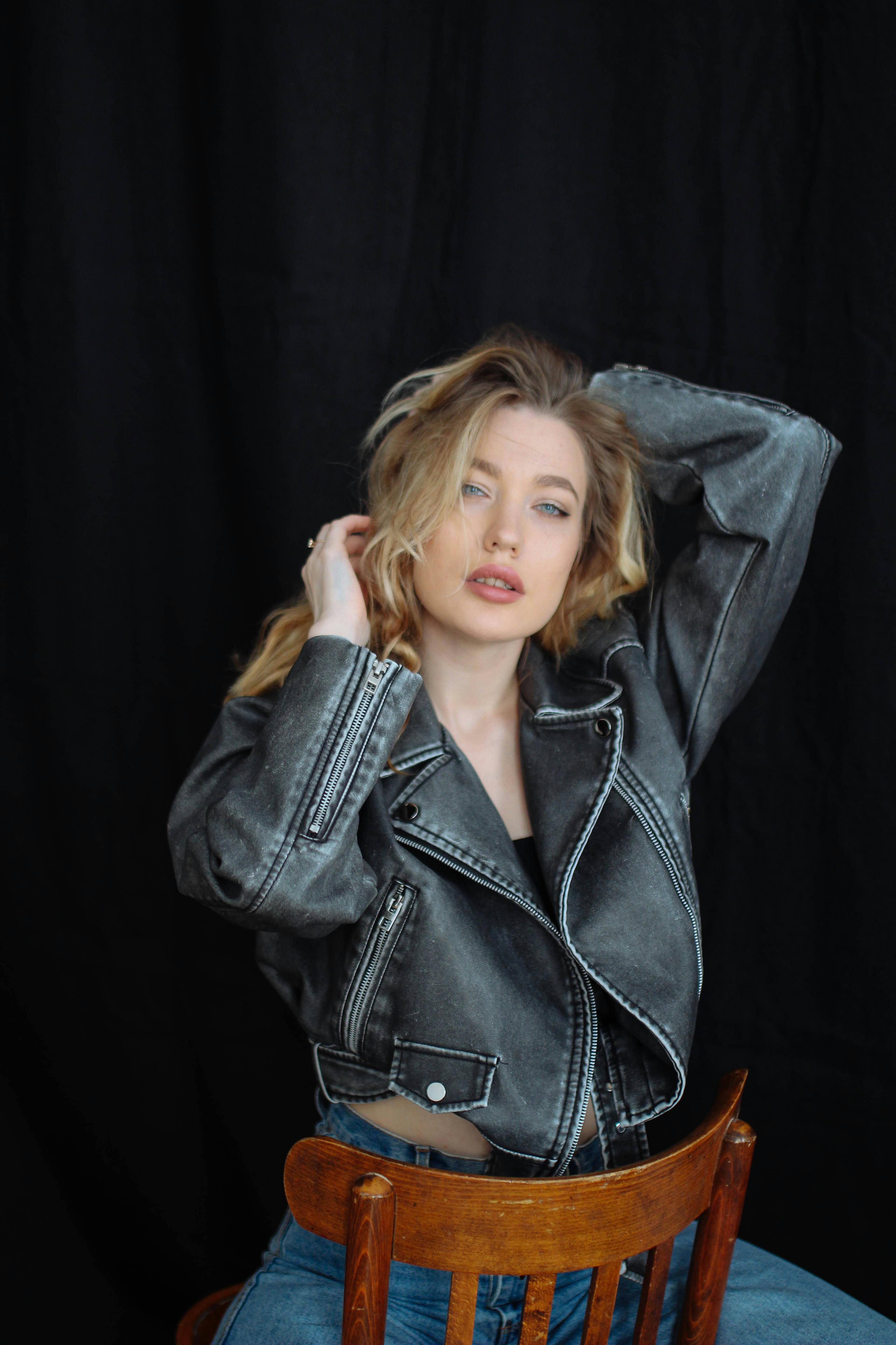 Woman in a Leather Jacket Sitting Backward on a Chair · Free Stock