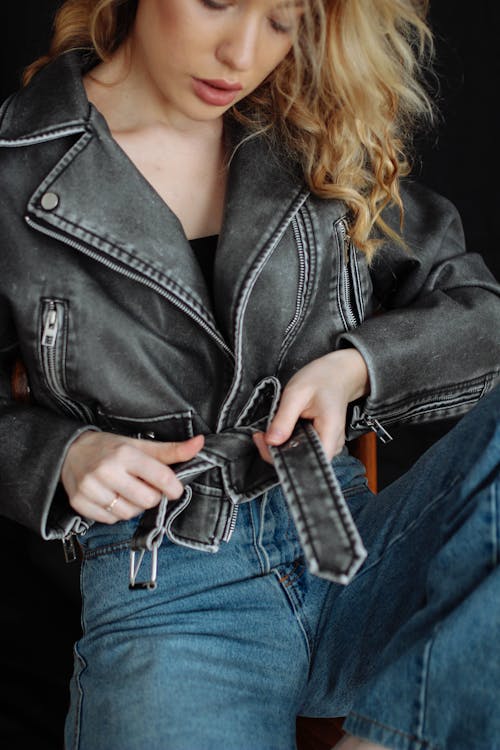 Young Woman Tying the Belt of Her Leather Jacket
