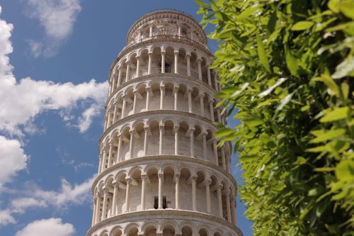 Free Stunning view of the Leaning Tower of Pisa on a sunny day with lush greenery. Stock Photo