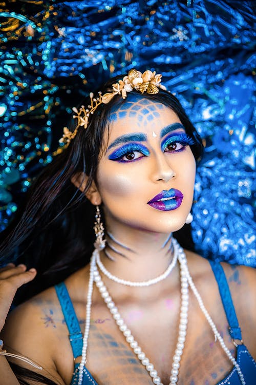 Close-up of Woman with Bright Makeup Posing on Blue Background