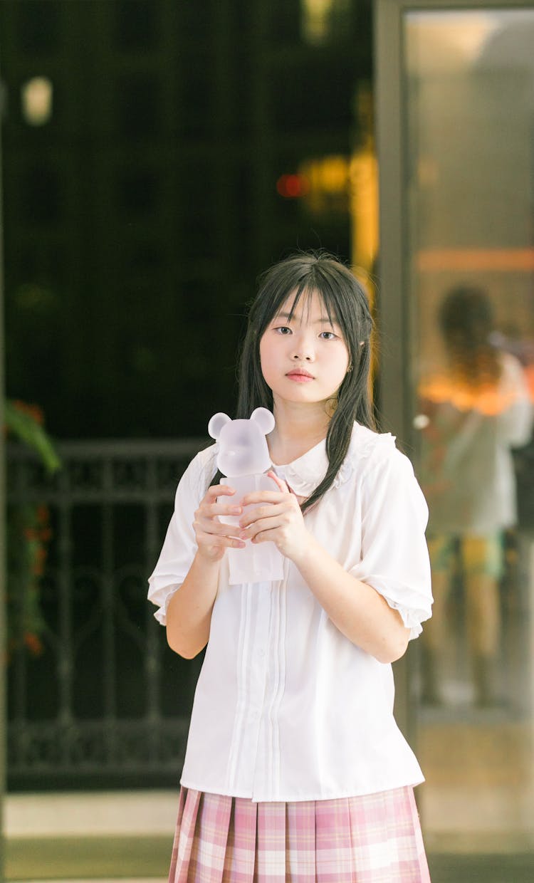 A Portrait Of A Young Girl Holding Mascot