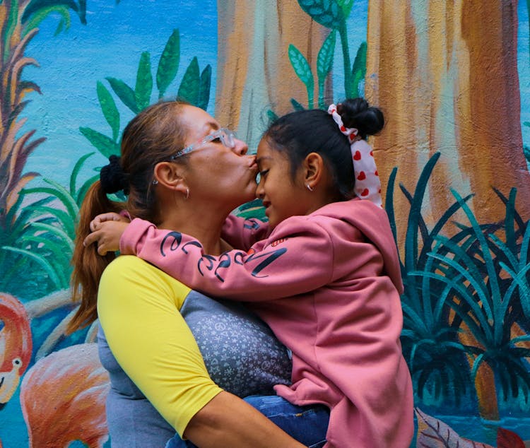 Mother Hugging And Kissing Daughter