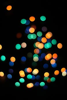 Vibrant blurred multicolor bokeh lights against a dark background, perfect for festive designs.