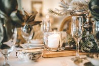 烛光餐桌布置精美，配有优雅的玻璃器皿和节日装饰，非常适合营造舒适的晚餐环境