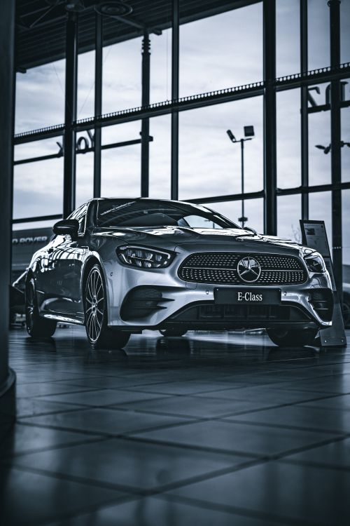 Free A stylish silver Mercedes E-Class displayed indoors, perfect for automotive enthusiasts. Stock Photo