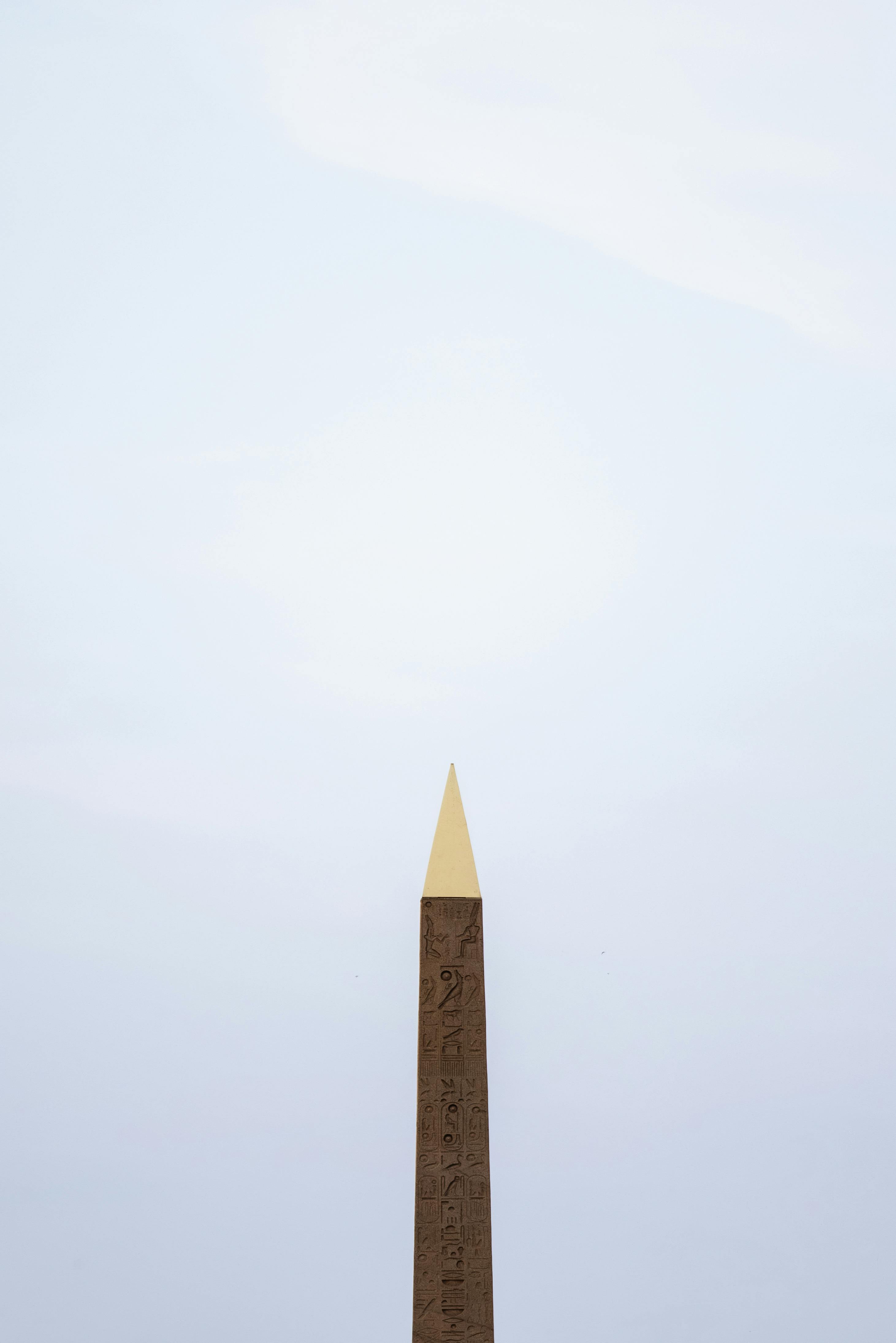 Free Minimalist shot of the Luxor Obelisk in Paris against a gray sky, highlighting its ancient grandeur. Stock Photo