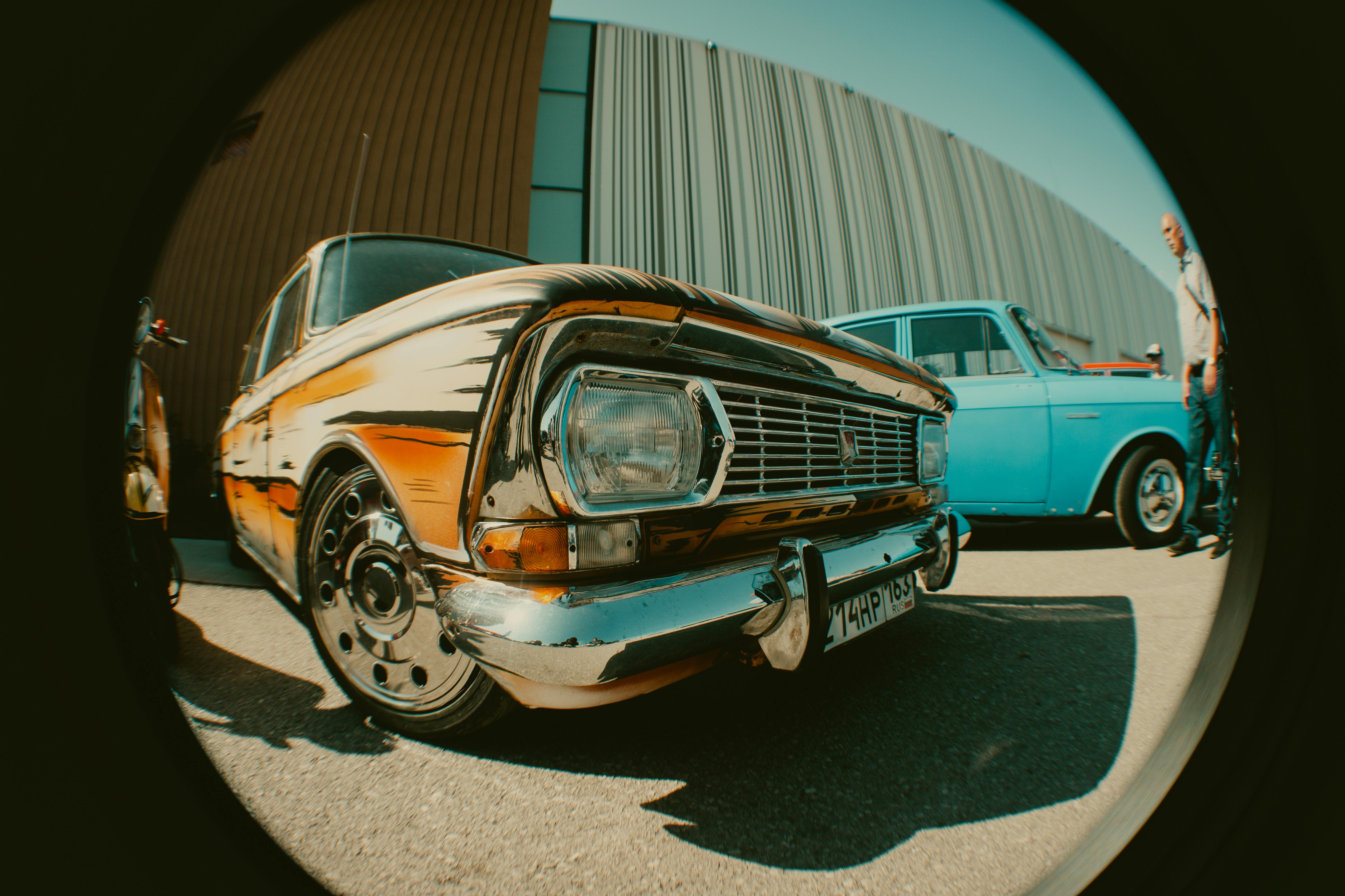 Fisheye lens captures vintage classic cars outdoors with retro charm.
