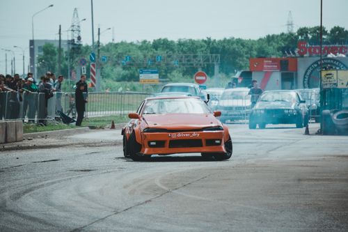Free Orange Nissan Silvia performing a drift in city car competition. Stock Photo