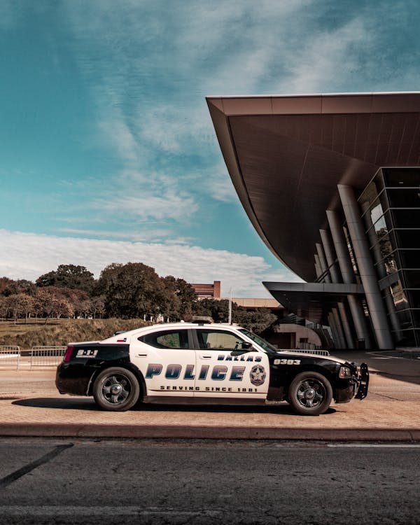 Free Police Car Parked Near Building Stock Photo