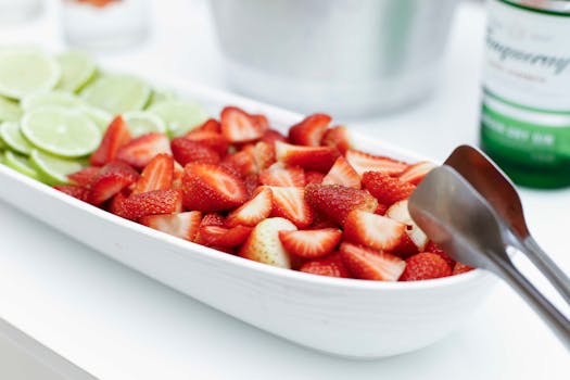 A bowl of fresh strawberry and lime slices ready for serving.