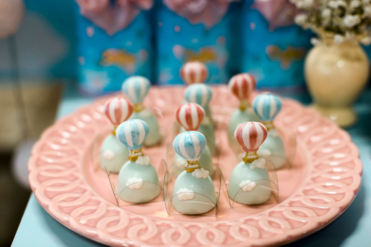 Delightful pastel balloon-themed sweets arranged on an elegant pink plate, perfect for celebrations.