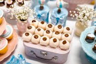 这张甜点桌布置精美，装饰柔和，配有各式甜点，非常适合庆祝活动