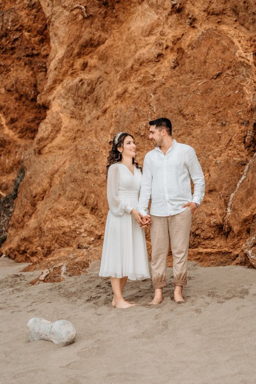 Couple in White Dress and Shirt Holding Hands