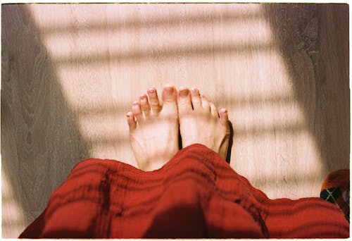 Základová fotografie zdarma na téma červená sukně, chodidla, dřevěná podlaha