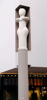 Contemporary sculpture on a column, adding modern charm to urban architecture.