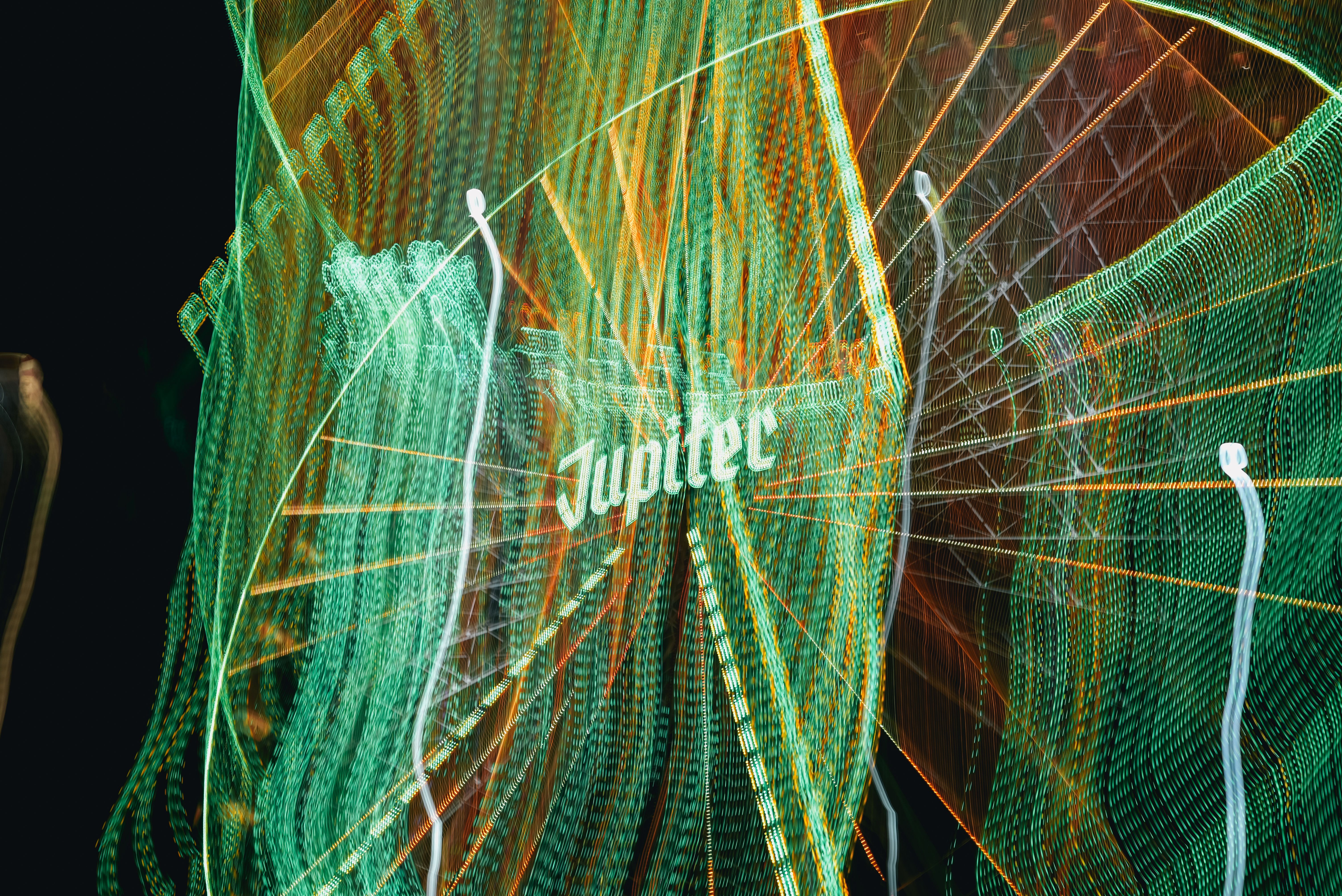 Abstract light trails with the word 'Jupiter', capturing vibrant colors and motion at night.