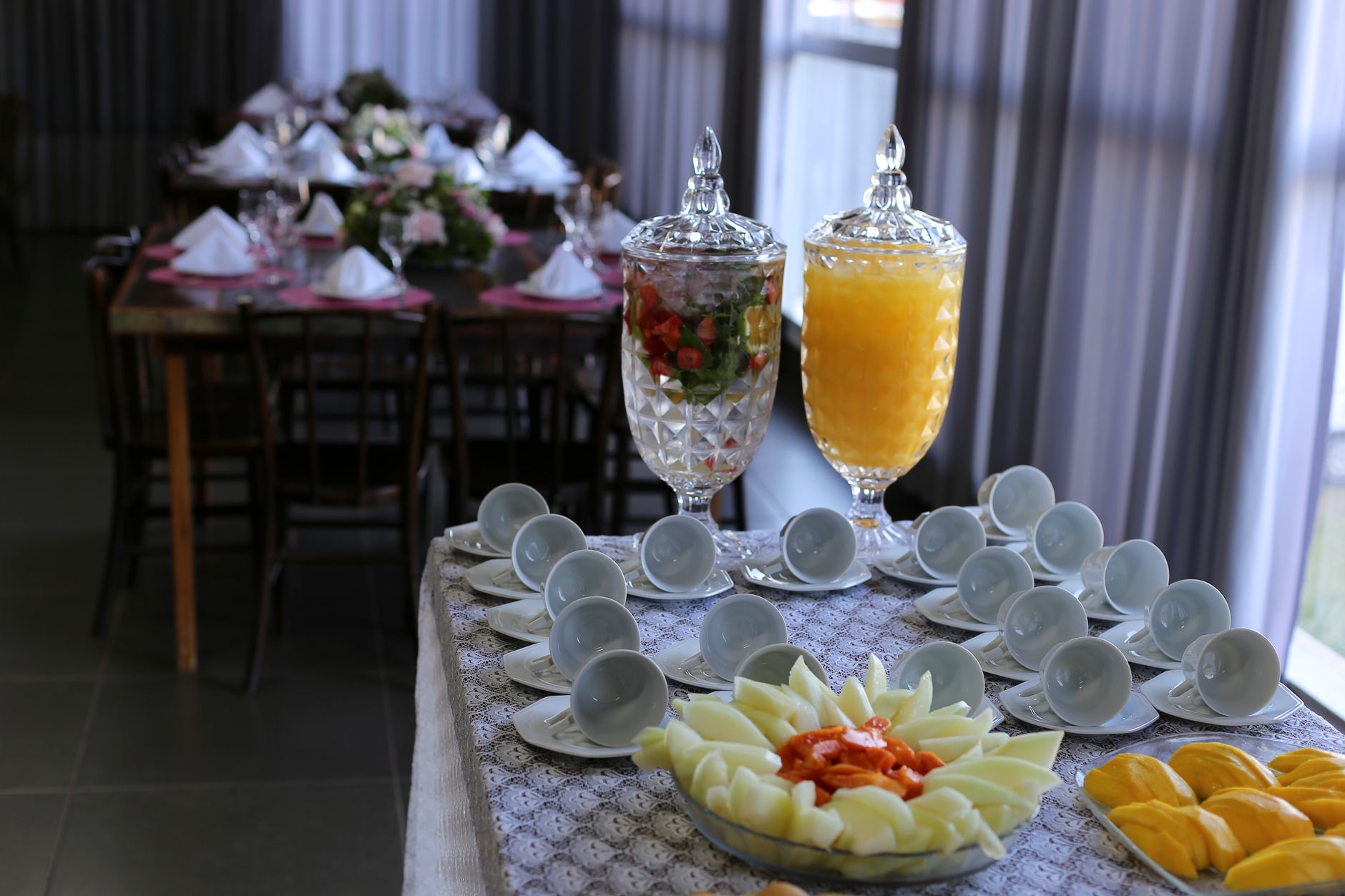 Sophisticated indoor table setup featuring fruit platters and beverages.