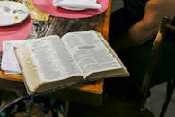 木桌上摊开的圣经旁放着餐盘和笔记，上面突出显示着《传道书》