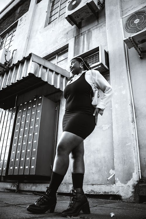 Woman Standing near Building in Black and White