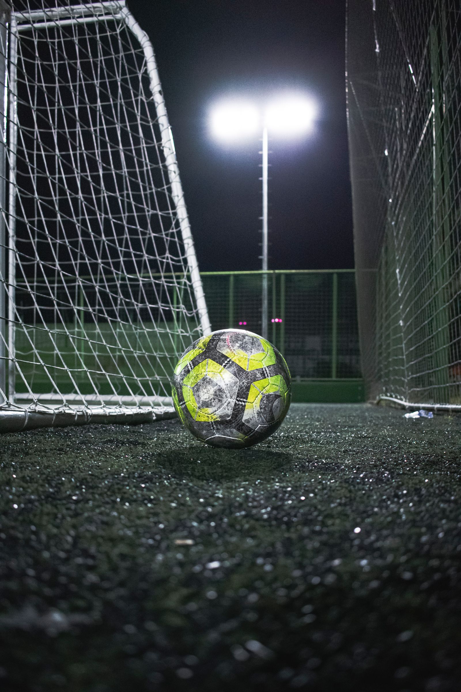 Football beside a goal under floodlights at night