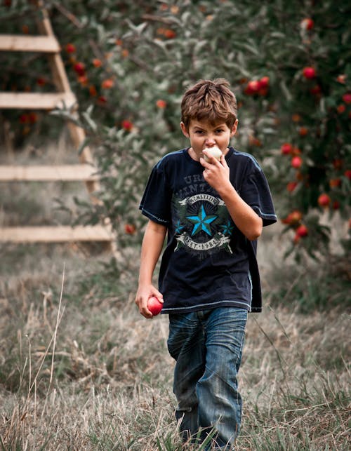 Photo D'un Garçon Mangeant Une Pomme