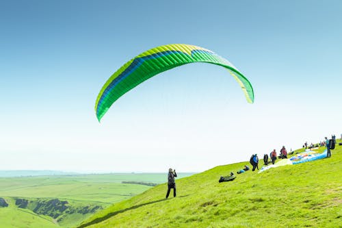 People Standing with Parachute on Hill