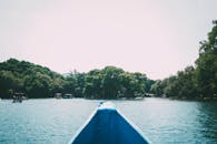 晴朗的日子里，一艘船静静航行在绿树成荫的湖泊中