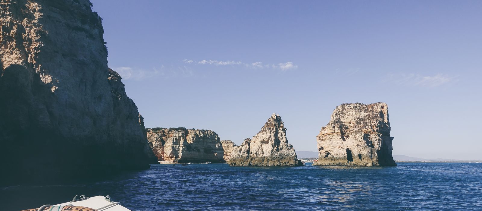 Tranquil scene of Algarve cliffs and ocean from a boat, ideal for travel and vacation themes.