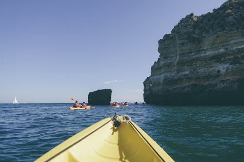 Photo of People Kayaking Near Rock Formation