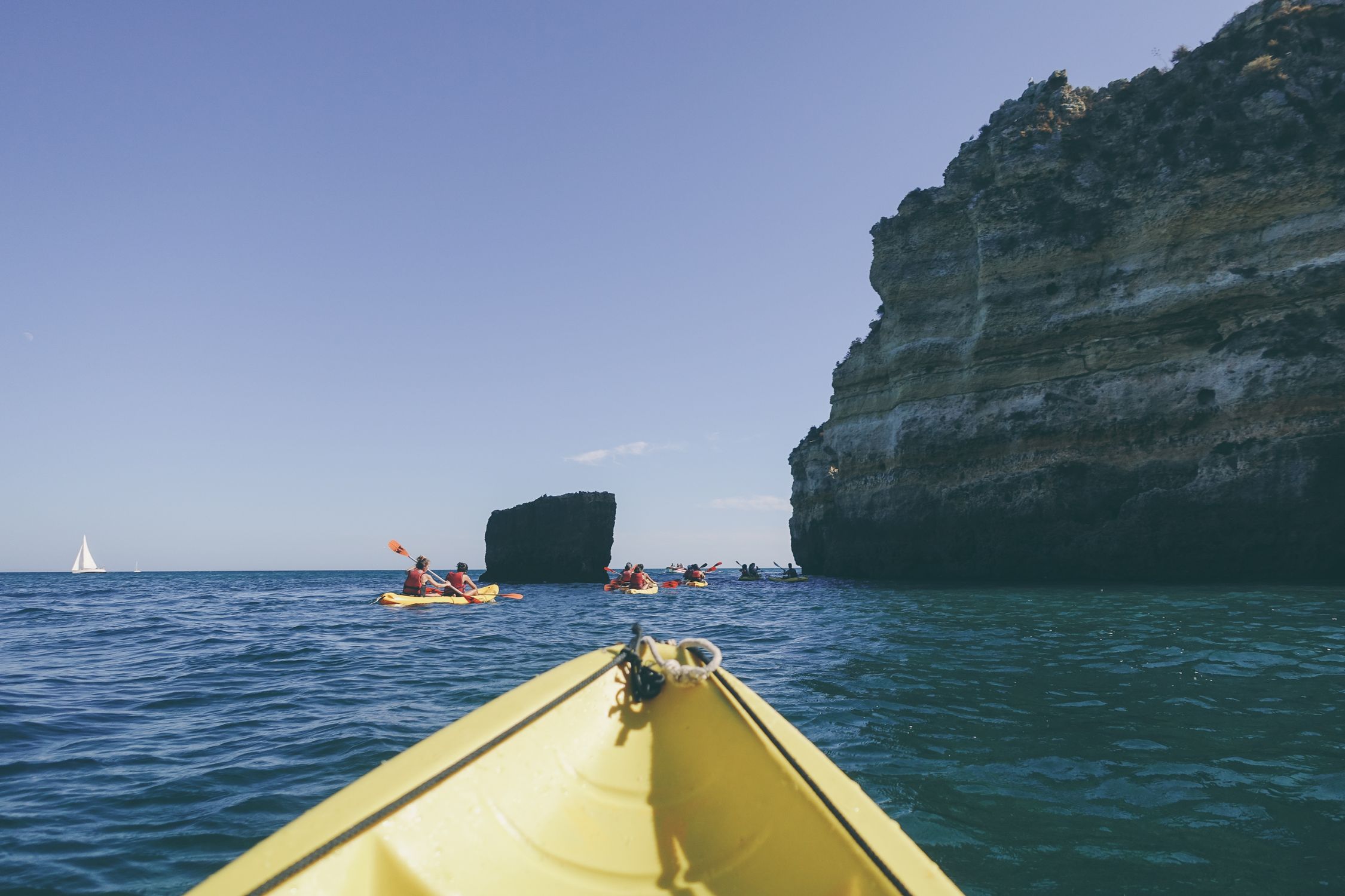 Photo of People Kayaking Near Rock Formation · Free Stock Photo
