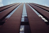 仰望一座带反光窗户的现代化摩天大楼，在晴朗的天空下