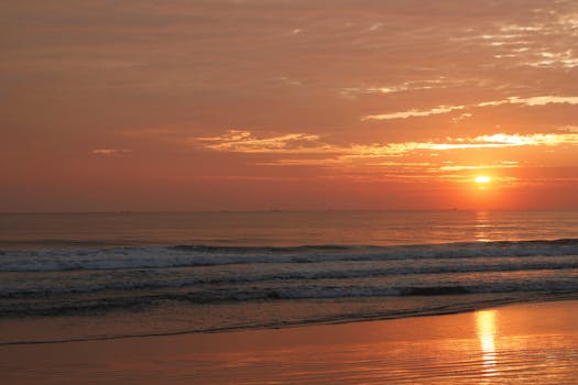 Experience the serene beauty of a sunset over Guaratuba Beach, Brazil with calming waves.