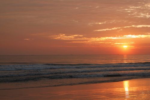 Free Experience the serene beauty of a sunset over Guaratuba Beach, Brazil with calming waves. Stock Photo