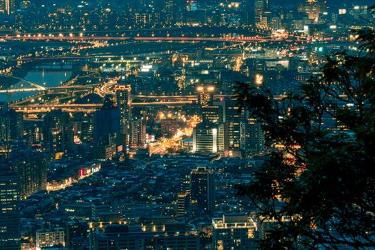 An illuminated urban cityscape showcasing modern architecture and city lights at twilight.