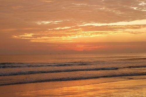 Free Mesmerizing sunset over Guaratuba Beach with golden skies and gentle waves. Stock Photo