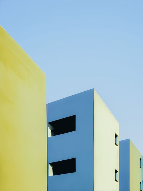 Free A minimalist shot of modern buildings with vibrant colors and a clear blue sky, showcasing urban architecture. Stock Photo