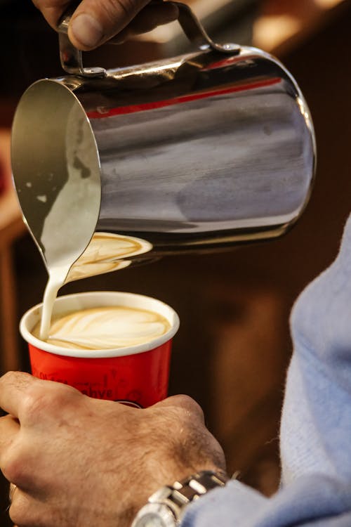 Man Pouring Coffee from Pitcher to Cup