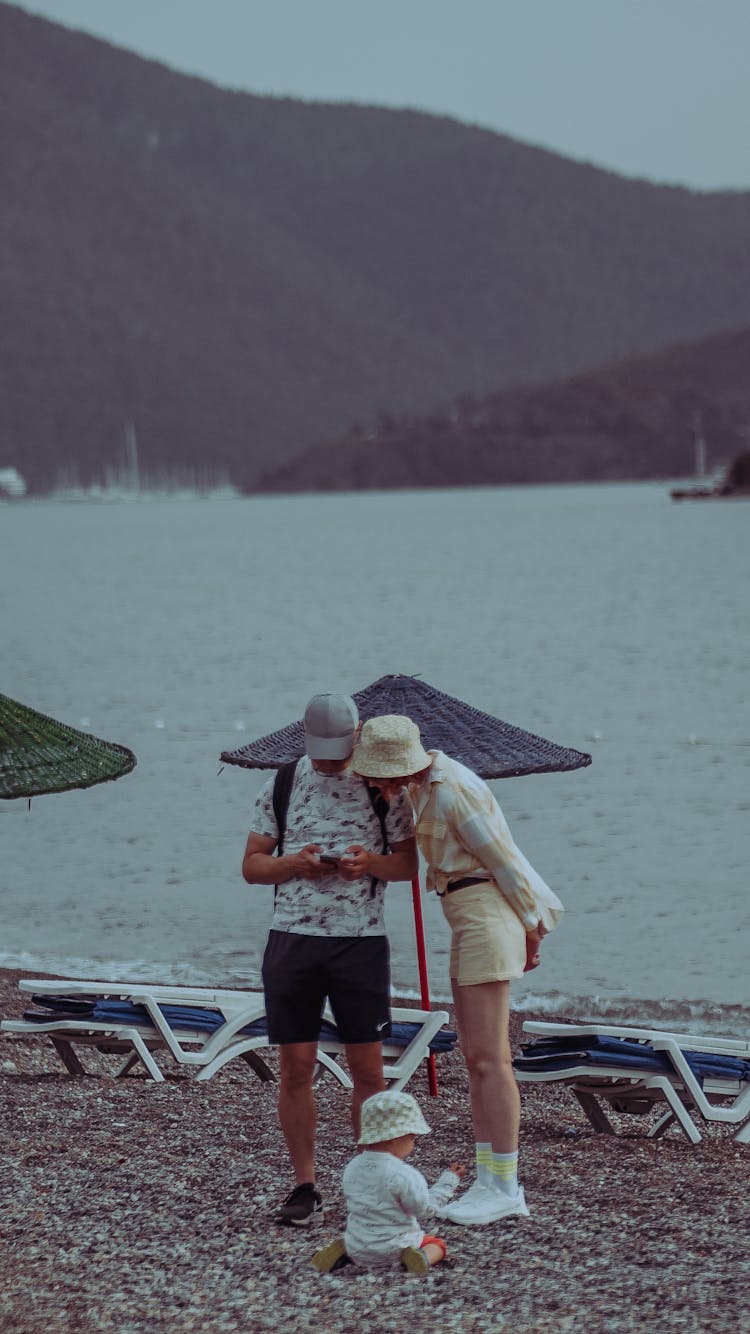 Parents With A Little Child On The Beach 