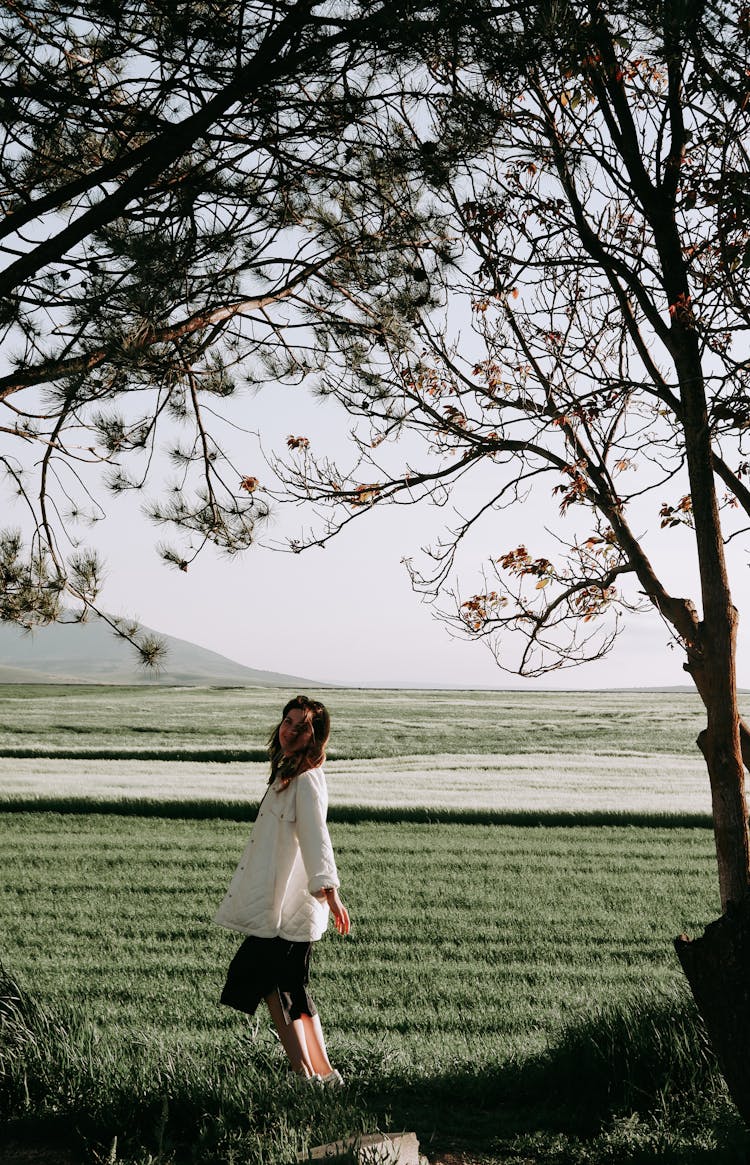 Woman Posing In A Green Field In The Wind