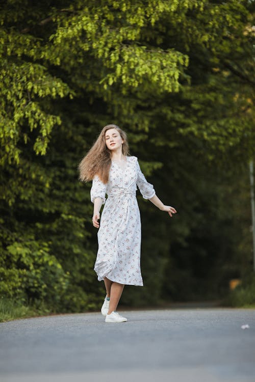 Woman in Sundress Standing on Road in Forest