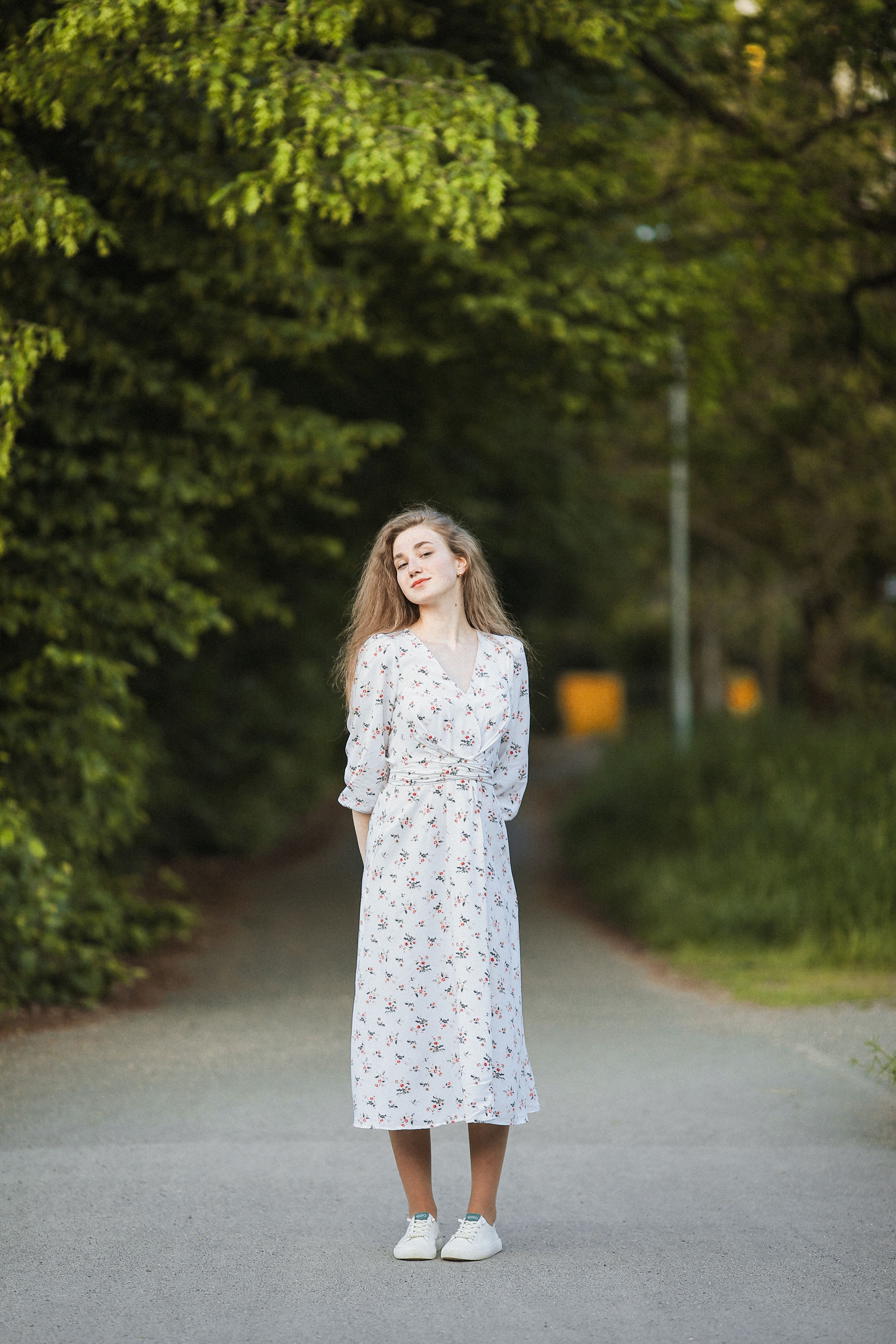 Woman in a Floral Dress Standing in the Park · Free Stock Photo