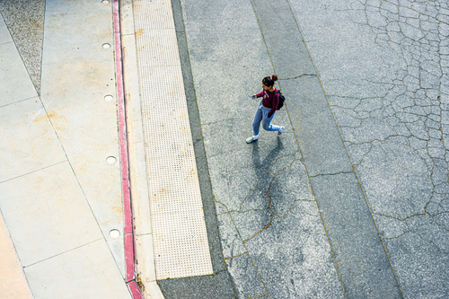 Free Aerial view of a woman walking on city pavement, captured from above. Stock Photo