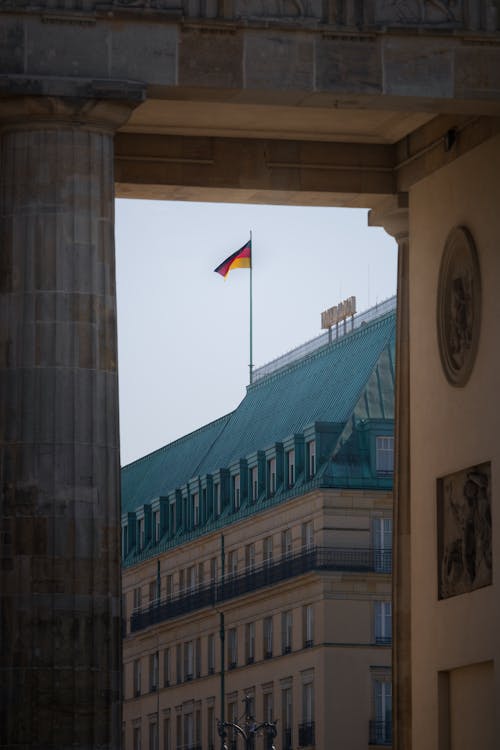 The german flag flies over the brandenburg gate in berlin