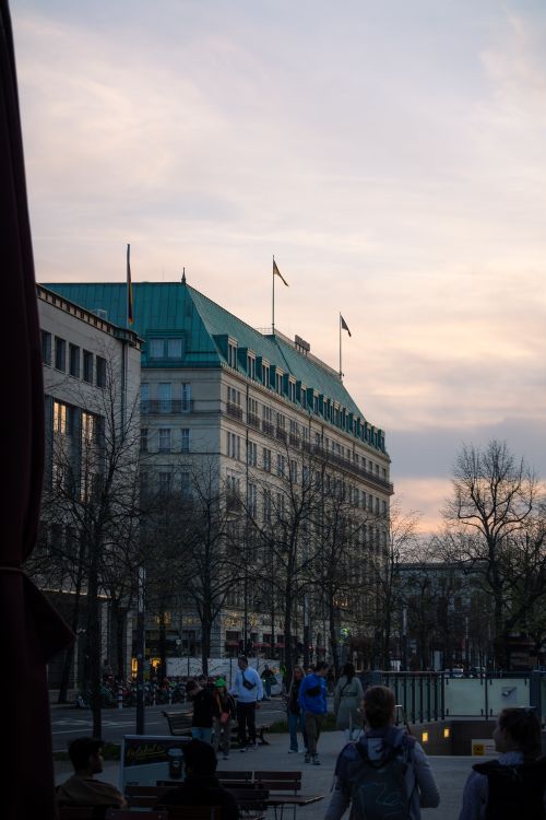 Free A bustling Berlin street scene featuring architecture, people, and sunset lighting. Stock Photo