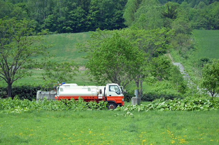 Laundry Management System — Water tank truck delivering water in a rural setting