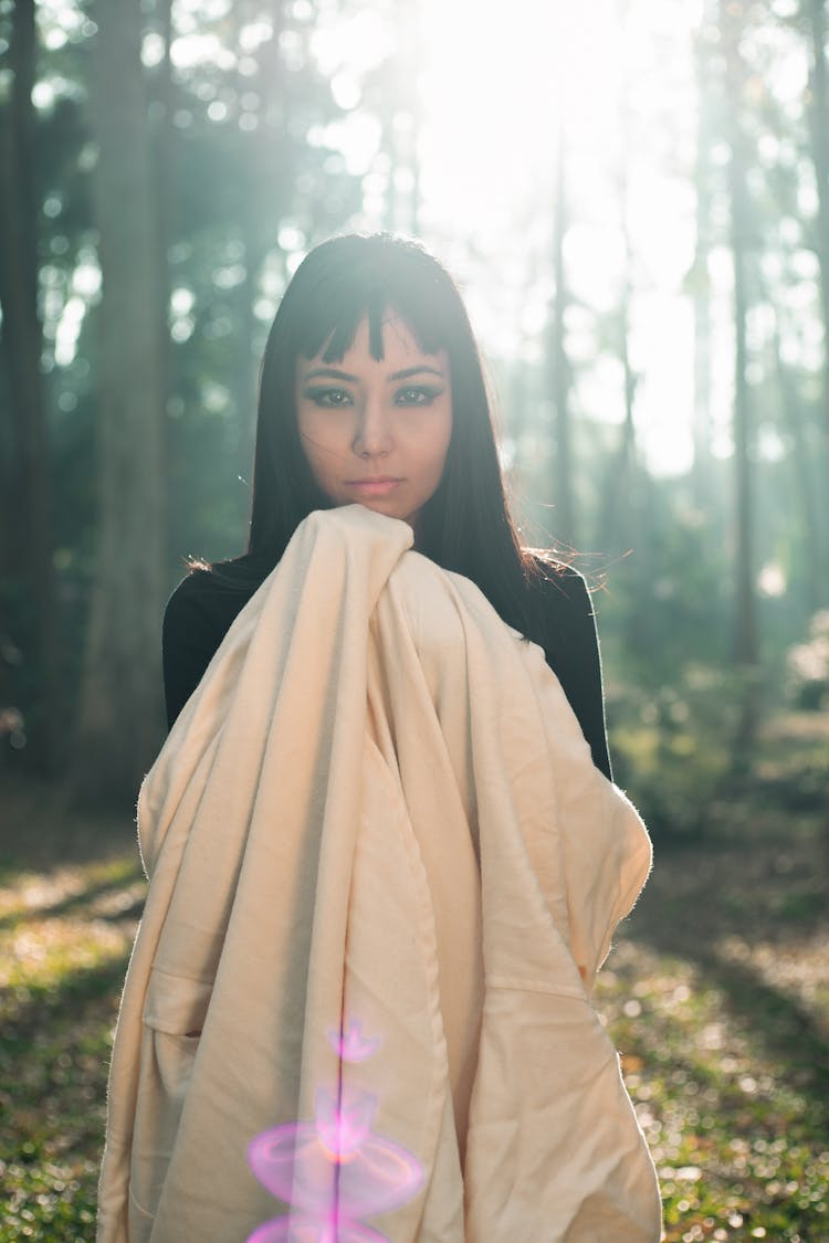 Woman Standing In Forest And Holding A Blanket 