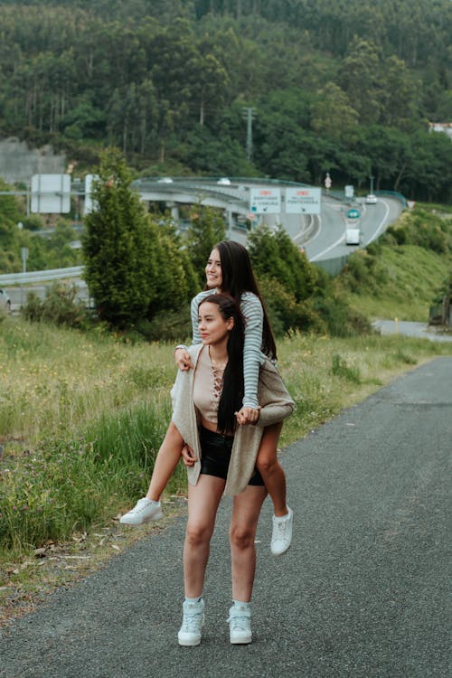 Teenage Girl Piggybacking her Friend 