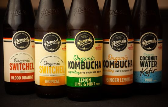 Close-up of five bottles featuring organic kombucha, switchel, and kefir with various flavors.